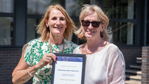 Two people standing side by side, holding a framed certificate